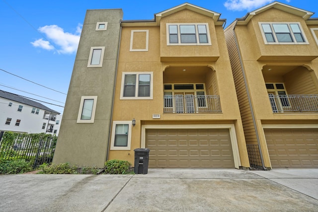 view of property featuring a garage and a balcony