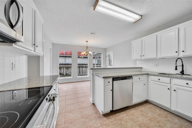 kitchen featuring pendant lighting, sink, white cabinetry, stainless steel appliances, and kitchen peninsula