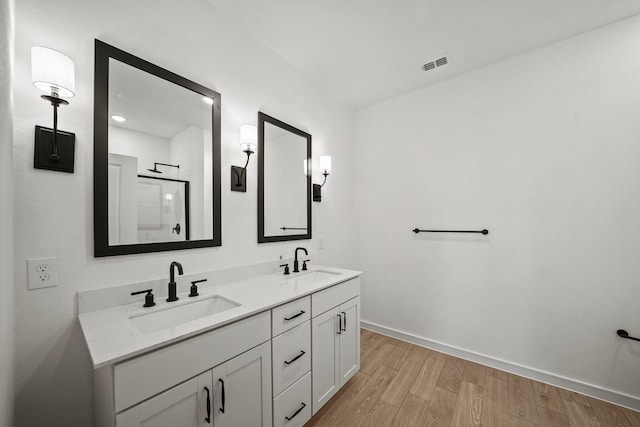 bathroom with wood-type flooring, vanity, and a shower