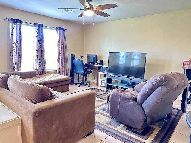 tiled living room featuring ceiling fan and a textured ceiling