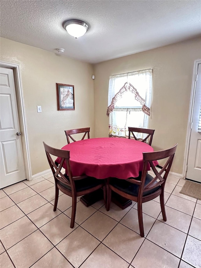 dining room with light tile patterned flooring and a textured ceiling