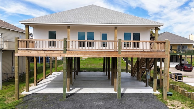 rear view of house with a deck, a carport, and covered porch