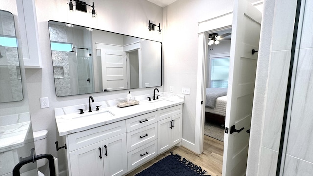 bathroom featuring vanity, wood-type flooring, ceiling fan, and walk in shower