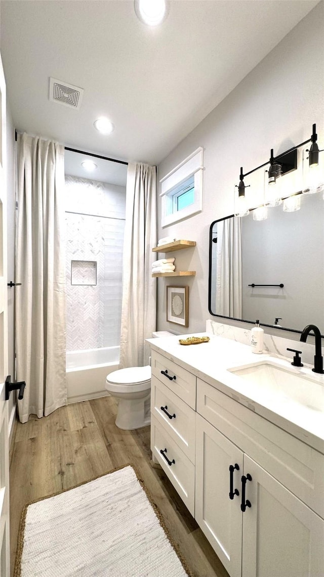 full bathroom featuring shower / bathtub combination with curtain, vanity, wood-type flooring, and toilet