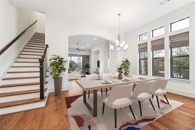 dining area featuring ceiling fan with notable chandelier and light hardwood / wood-style flooring