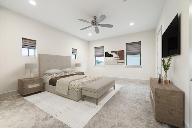 carpeted bedroom with multiple windows and ceiling fan