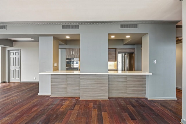 kitchen featuring dark hardwood / wood-style flooring, stainless steel appliances, and kitchen peninsula