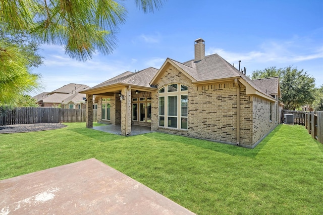 back of house featuring a yard and a patio area