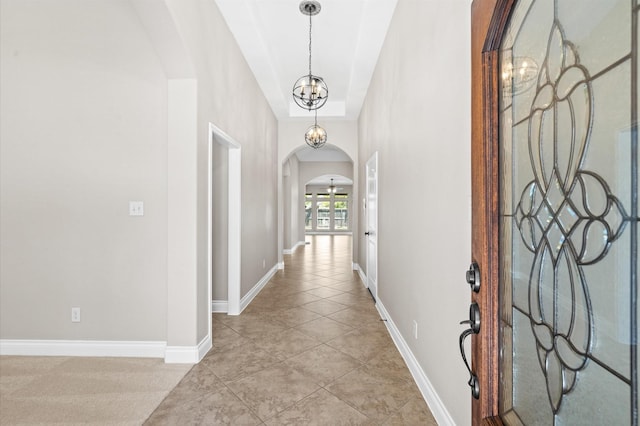 hallway featuring light tile patterned floors and a chandelier