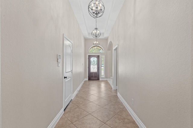 doorway featuring light tile patterned floors and an inviting chandelier