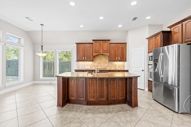 kitchen featuring lofted ceiling, sink, hanging light fixtures, stainless steel appliances, and a kitchen island with sink