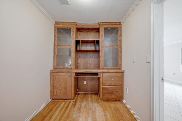 unfurnished office featuring crown molding and light wood-type flooring