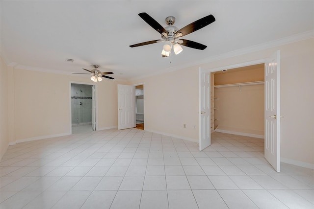 unfurnished bedroom with ceiling fan, a walk in closet, ornamental molding, and light tile patterned flooring