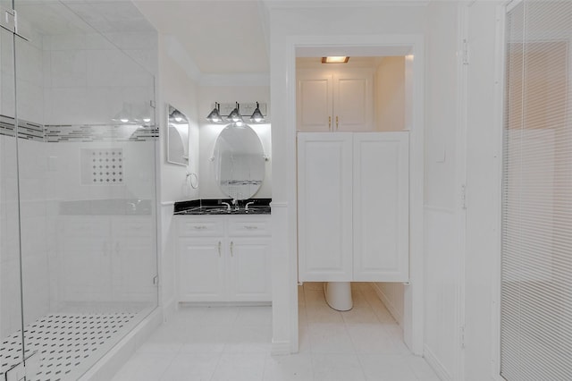 bathroom with an enclosed shower, vanity, and tile patterned flooring