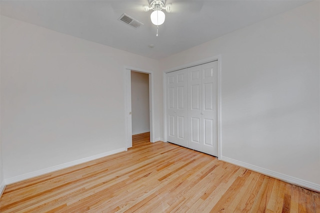 unfurnished bedroom with light hardwood / wood-style floors, a closet, and ceiling fan