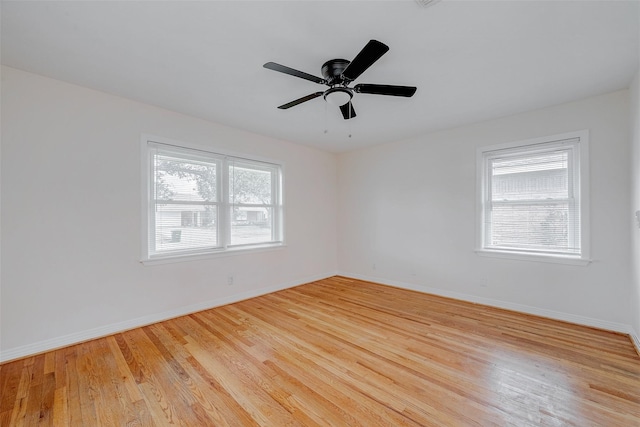 spare room featuring ceiling fan, a healthy amount of sunlight, and light wood-type flooring