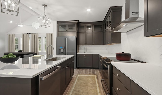 kitchen with appliances with stainless steel finishes, hardwood / wood-style floors, lofted ceiling, sink, and wall chimney exhaust hood