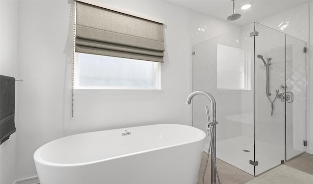 bathroom with tile patterned flooring and separate shower and tub