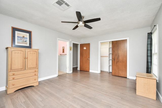 unfurnished bedroom with ceiling fan, light hardwood / wood-style floors, and a closet