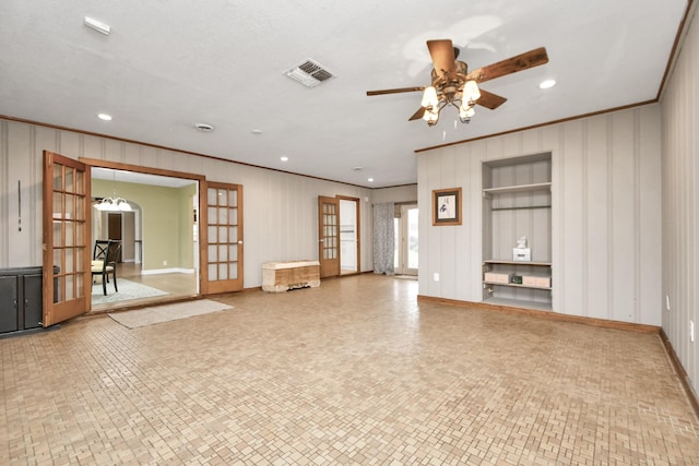 unfurnished living room with ceiling fan with notable chandelier and ornamental molding