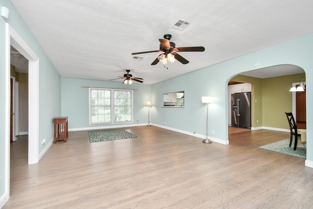 unfurnished living room with ceiling fan and light hardwood / wood-style floors