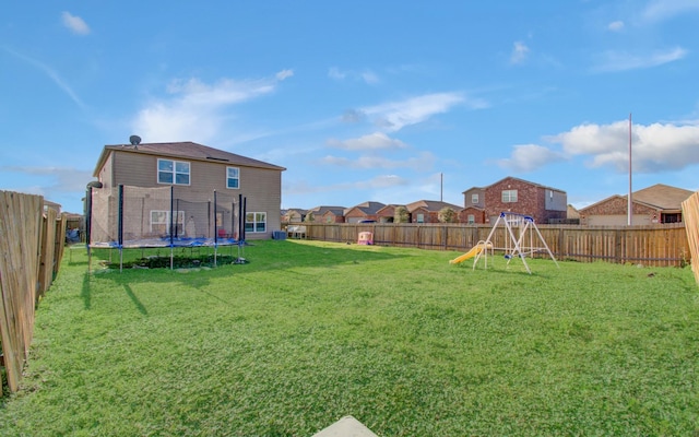 view of yard featuring a playground and a trampoline