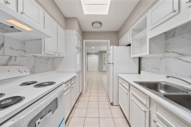 kitchen featuring a skylight, tasteful backsplash, white cabinetry, sink, and white appliances