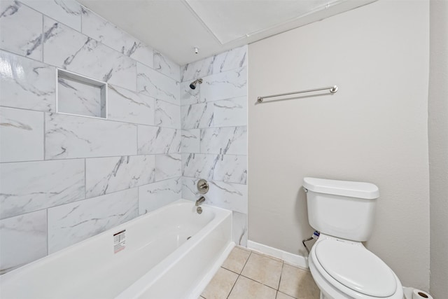 bathroom featuring tiled shower / bath, toilet, and tile patterned flooring