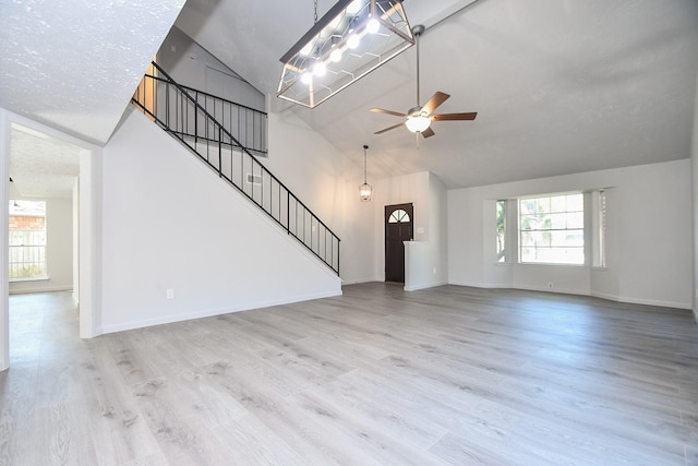 unfurnished living room featuring high vaulted ceiling, ceiling fan, and light wood-type flooring