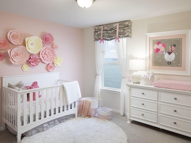 carpeted bedroom featuring multiple windows and a crib