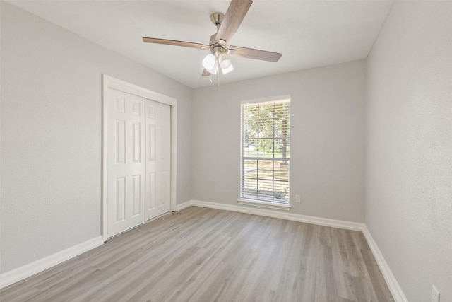 unfurnished bedroom with ceiling fan, a closet, and light wood-type flooring