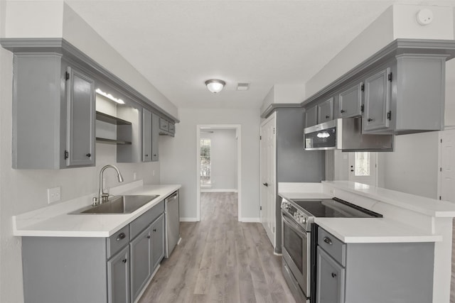 kitchen featuring gray cabinets, appliances with stainless steel finishes, and sink