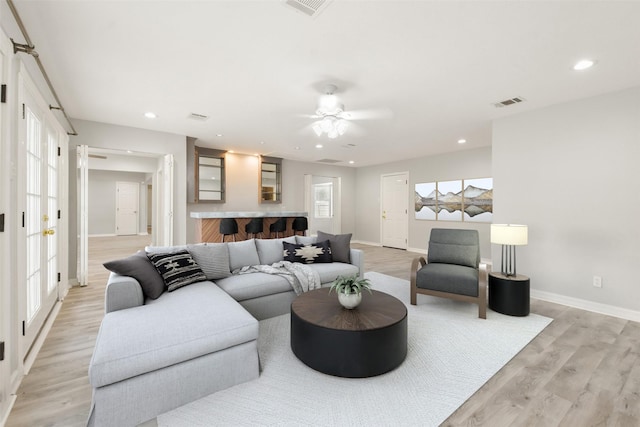 living room with light hardwood / wood-style floors and ceiling fan