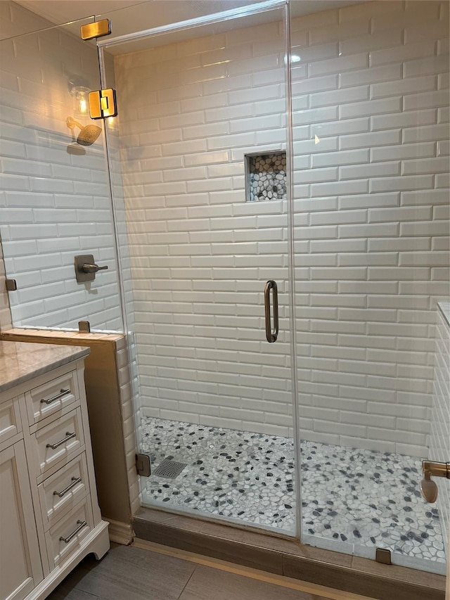 bathroom with walk in shower, tile patterned floors, and vanity