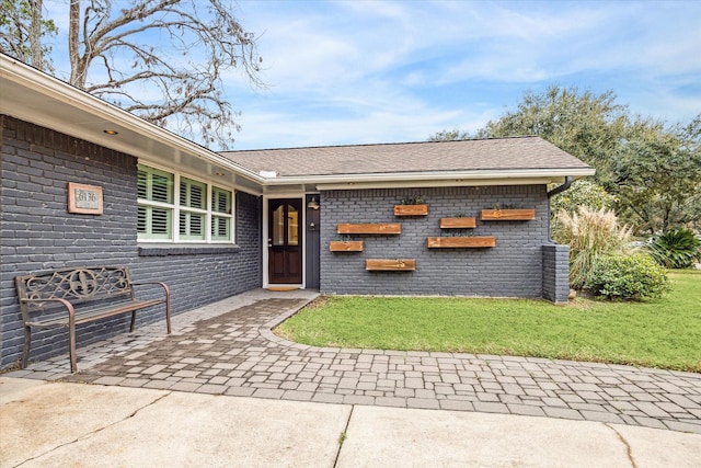 entrance to property featuring a yard and a patio