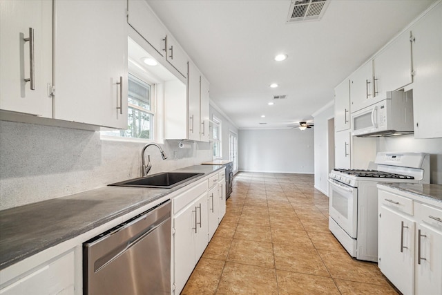 kitchen with light tile patterned flooring, sink, tasteful backsplash, white appliances, and white cabinets