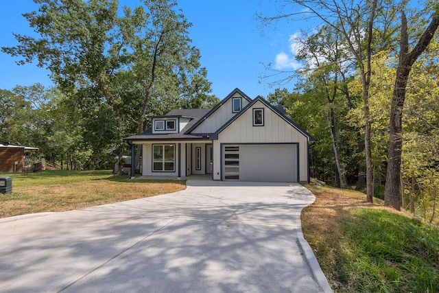 view of front facade with a garage, a front lawn, and covered porch