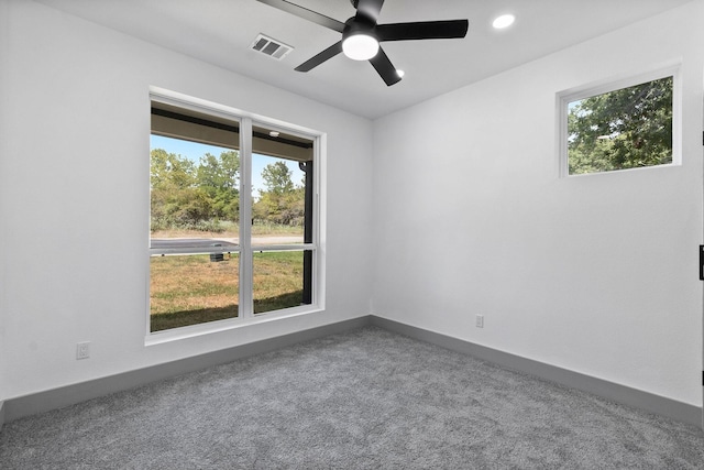 unfurnished room featuring a wealth of natural light, ceiling fan, and carpet