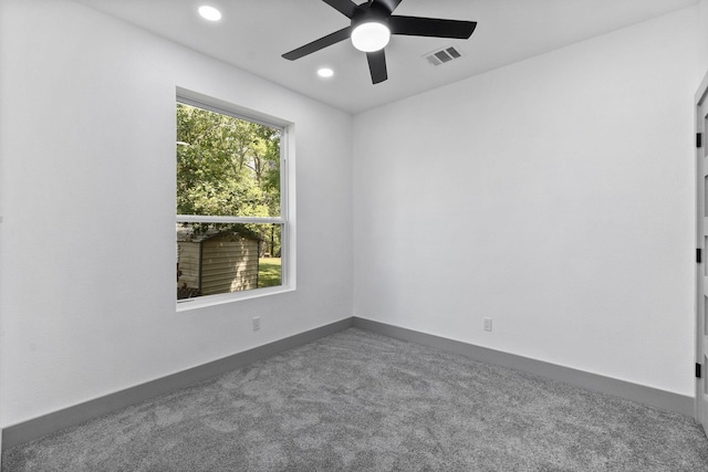 unfurnished room featuring ceiling fan and dark colored carpet