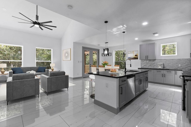 kitchen featuring pendant lighting, dishwasher, sink, gray cabinetry, and a center island with sink