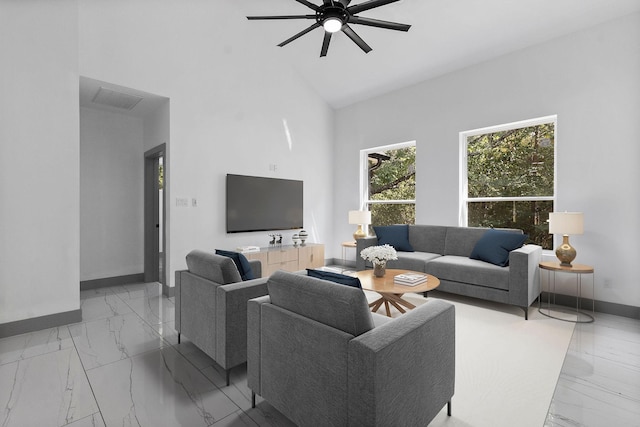 living room with a towering ceiling and ceiling fan