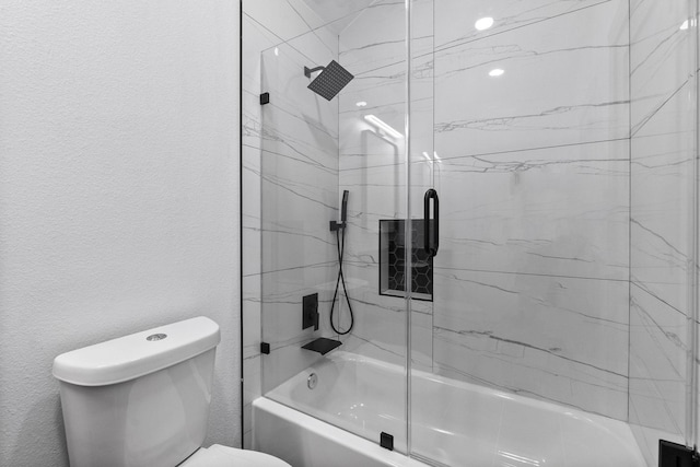 bathroom with shower / bath combination with glass door and toilet