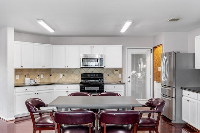 kitchen with tasteful backsplash, appliances with stainless steel finishes, and white cabinets