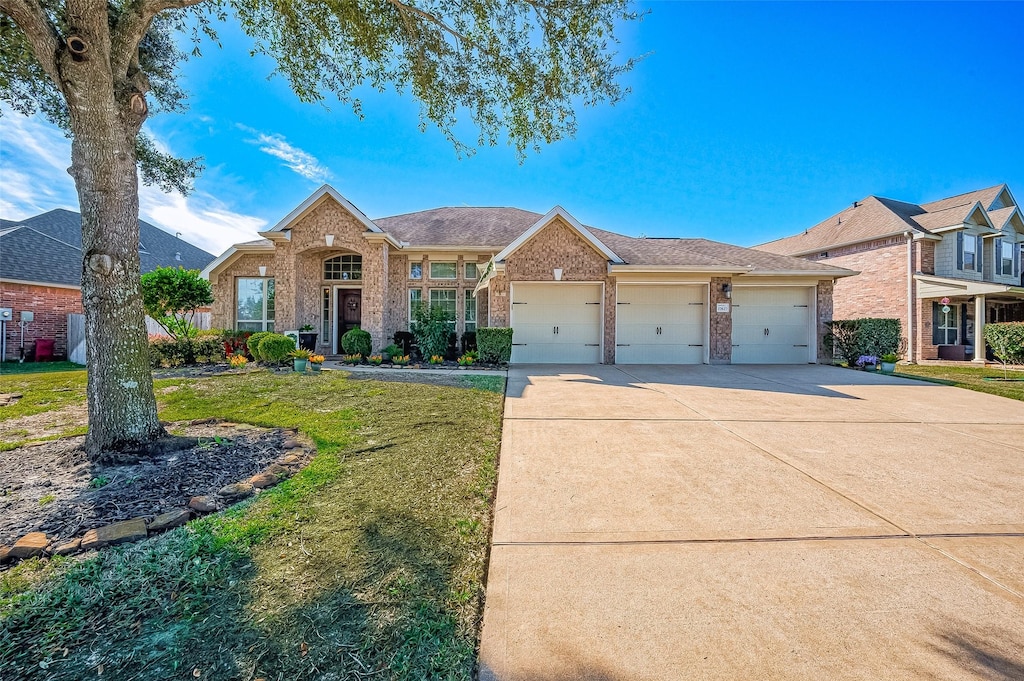 ranch-style house featuring a garage and a front lawn