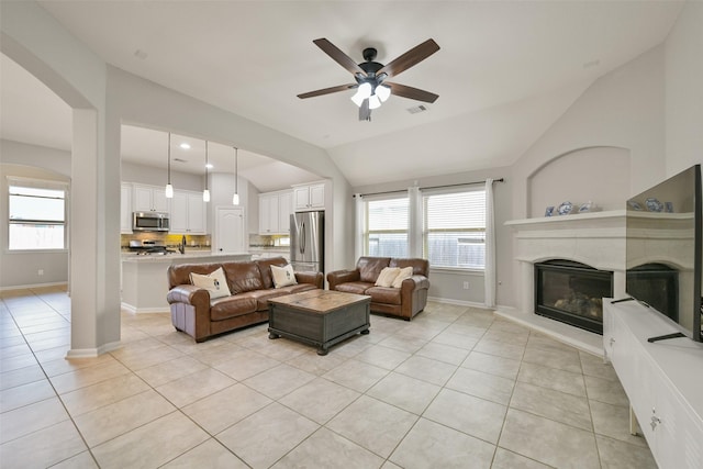 tiled living room with lofted ceiling and ceiling fan