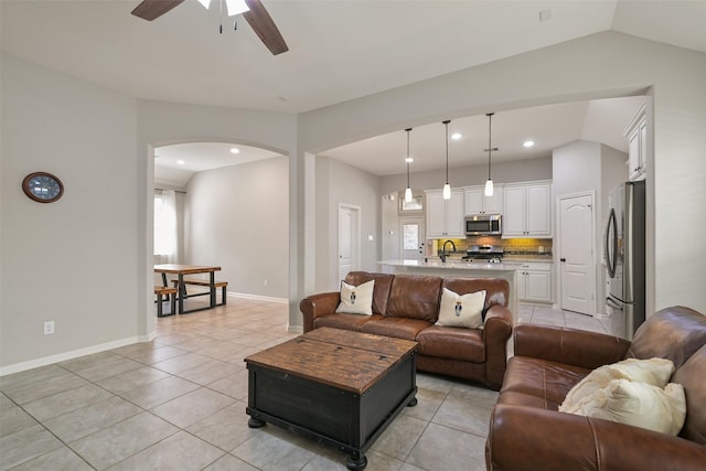 tiled living room featuring lofted ceiling, sink, and ceiling fan