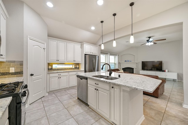 kitchen with sink, pendant lighting, stainless steel appliances, a kitchen island with sink, and white cabinets