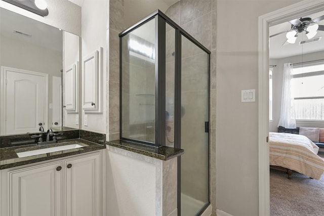 bathroom with ceiling fan, vanity, and a shower with door