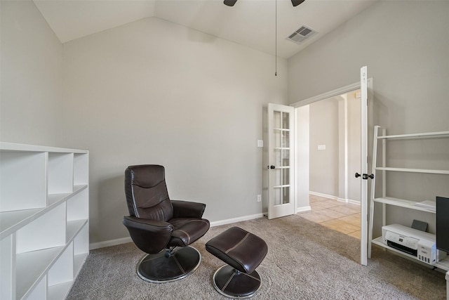 living area with french doors, ceiling fan, vaulted ceiling, and light carpet