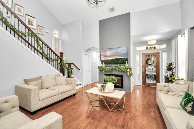 living room with dark hardwood / wood-style flooring and high vaulted ceiling